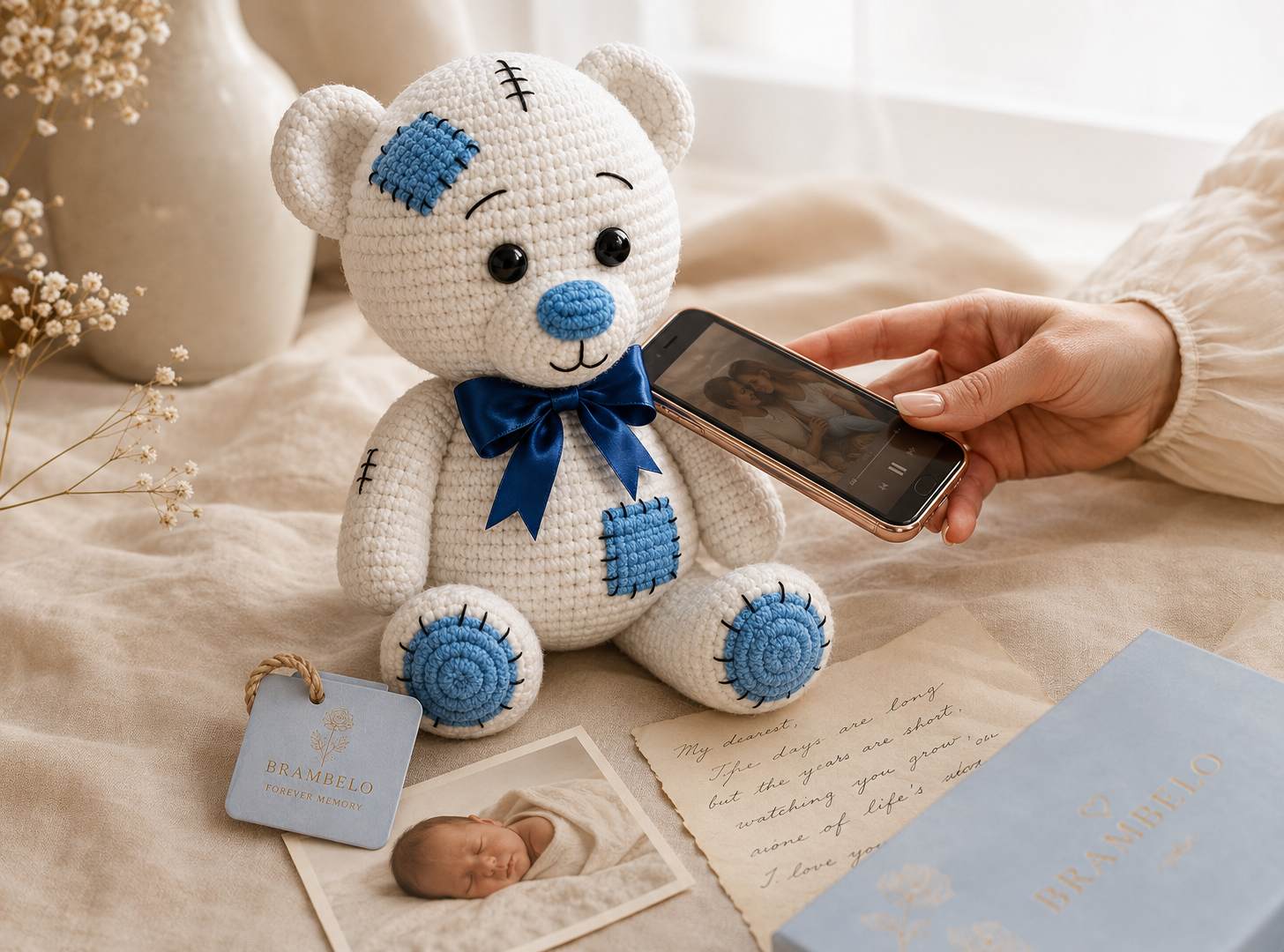 Benny beside a Brambelo Forever Memory keepsake while a phone is held close, surrounded by a newborn photograph and handwritten family letter